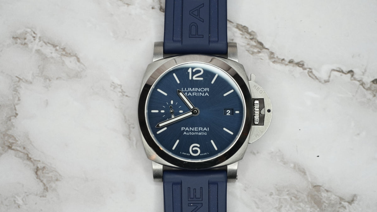 Panerai Luminor Marina PAM01370 with blue dial, stainless steel case and blue rubber strap, front view on marble.