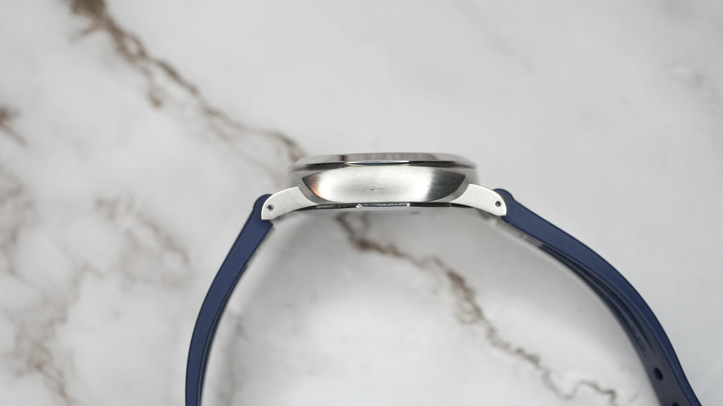 Opposite case-side profile of Panerai Luminor Marina PAM01370 showing brushed steel surface and blue rubber strap.